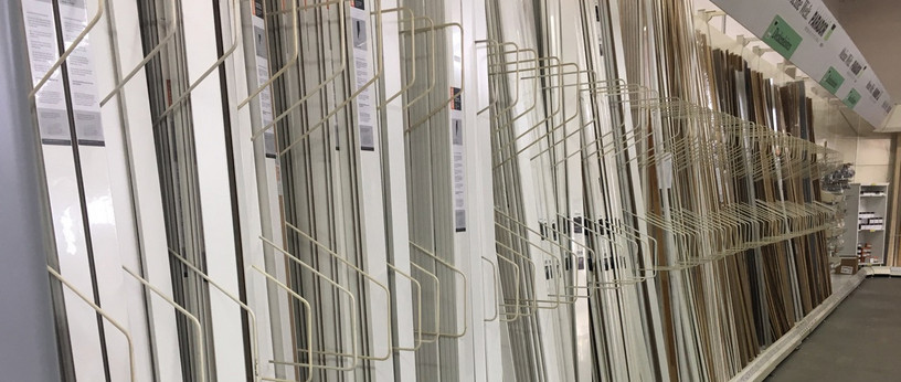 Vielfältige Auswahl an weißen und dekorativen Fußleisten in einem Baumarkt oder Holzhandel, sauber sortiert im Regal.