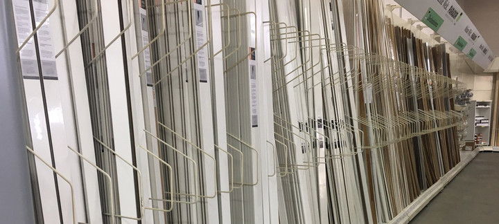 Vielfältige Auswahl an weißen und dekorativen Fußleisten in einem Baumarkt oder Holzhandel, sauber sortiert im Regal.