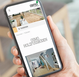Smartphone zeigt die Osmo-Website mit dem Bereich Holzfußböden – Produktübersicht mit Bildern und Navigation.
